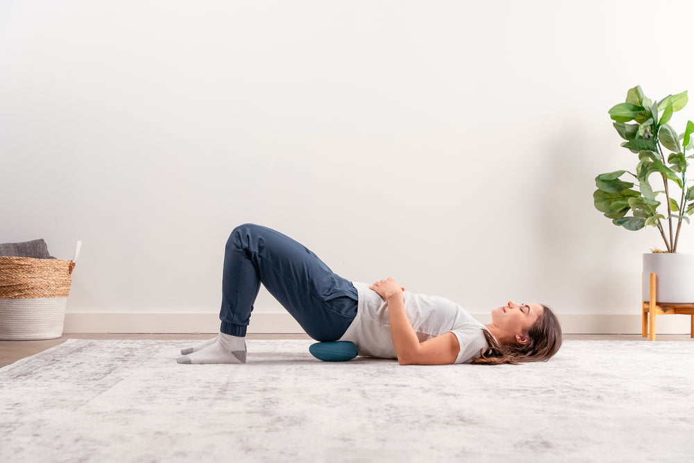 Image of model using the HALO Waist Stretch Cushion in the Waist area while lying on the floor.